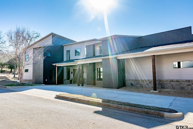 view of front of home with driveway and brick siding