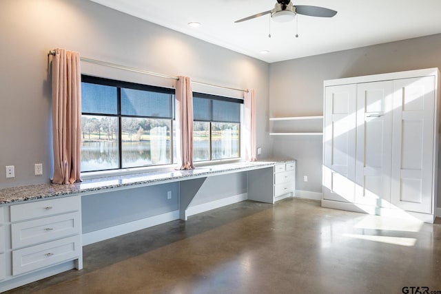 unfurnished office featuring recessed lighting, finished concrete floors, built in study area, ceiling fan, and baseboards