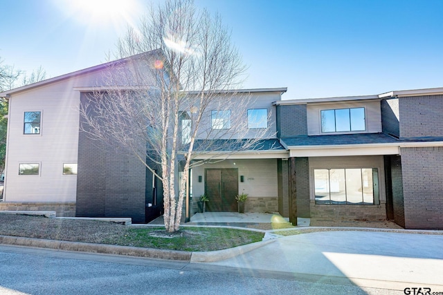 view of front of property with a patio and brick siding