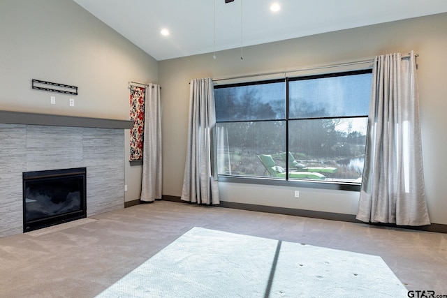 carpeted living room with lofted ceiling, a stone fireplace, recessed lighting, and baseboards