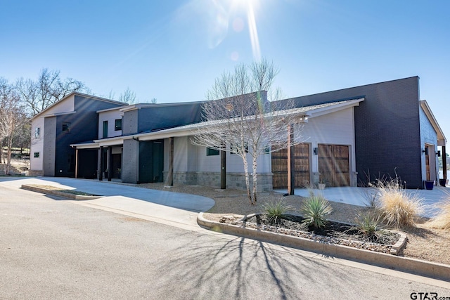 view of front of property featuring brick siding and driveway