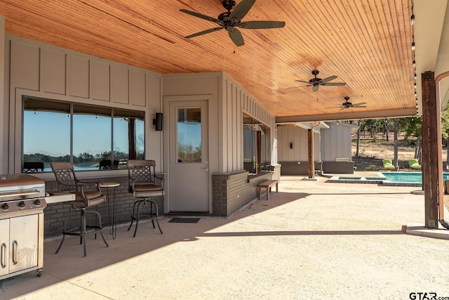 view of patio / terrace featuring ceiling fan, an outdoor pool, and grilling area