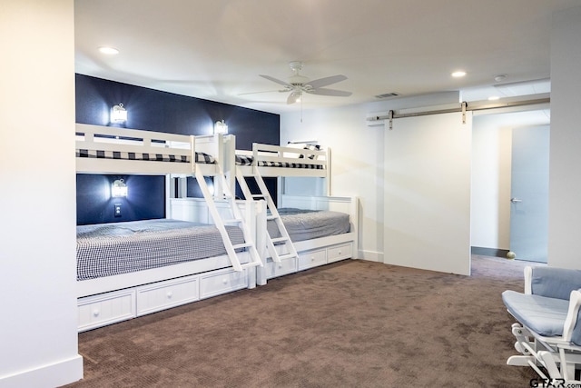 unfurnished bedroom with carpet, visible vents, recessed lighting, and a barn door