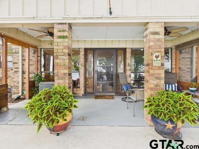 14227 Melody Ln, Malakoff, TX 75148 - entrance to property with ceiling fan, board and batten siding, and covered porch