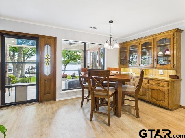 14227 Melody Ln, Malakoff, TX 75148 - dining space featuring ornamental molding, light wood-style floors, a chandelier, and baseboards