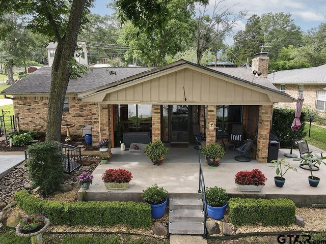 14227 Melody Ln, Malakoff, TX 75148 - back of house with brick siding, roof with shingles, a patio, and a chimney