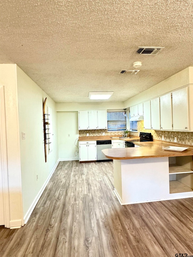 kitchen with black range with electric stovetop, dishwasher, kitchen peninsula, light hardwood / wood-style floors, and white cabinets