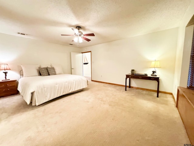 carpeted bedroom featuring ceiling fan and a textured ceiling