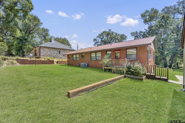 109 Maxine St, Mineola, TX 75773 - rear view of house with a lawn, metal roof, central air condition unit, and brick siding