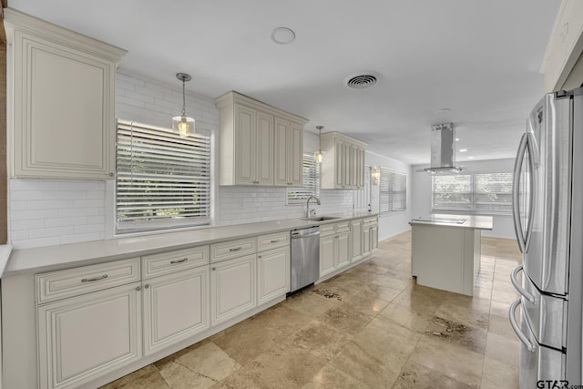 109 Maxine St, Mineola, TX 75773 - kitchen featuring appliances with stainless steel finishes, a sink, island exhaust hood, backsplash, and decorative light fixtures