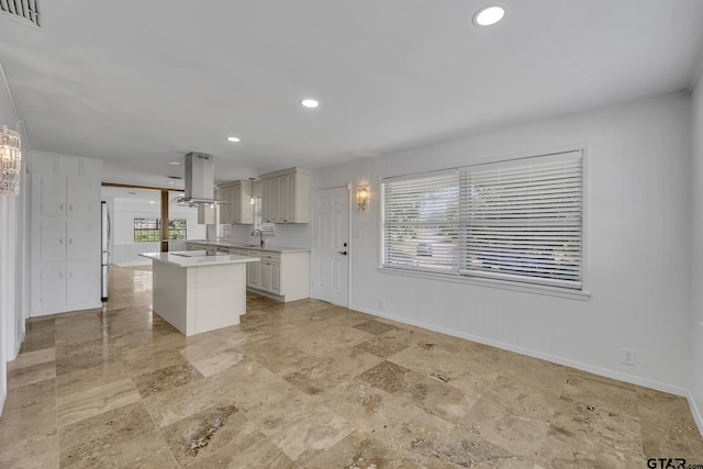 109 Maxine St, Mineola, TX 75773 - kitchen with island range hood, light countertops, a kitchen island, freestanding refrigerator, and recessed lighting