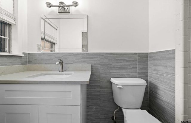 109 Maxine St, Mineola, TX 75773 - bathroom featuring toilet, vanity, a wainscoted wall, and tile walls