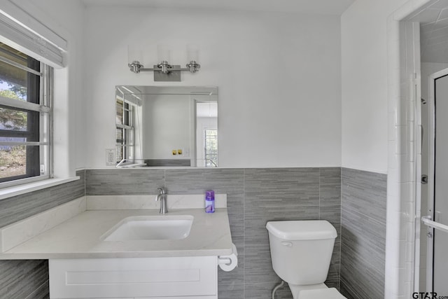 109 Maxine St, Mineola, TX 75773 - full bath with vanity, toilet, tile walls, a wainscoted wall, and a shower with door