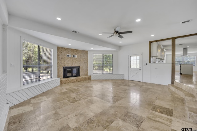 109 Maxine St, Mineola, TX 75773 - unfurnished living room featuring ceiling fan, a fireplace, stone finish floors, and recessed lighting