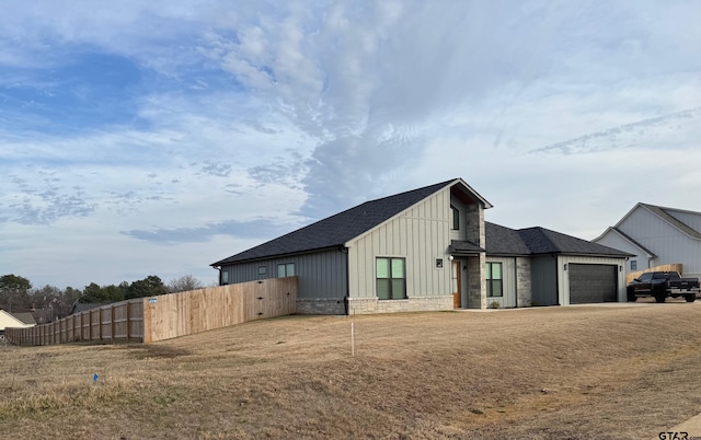 view of side of property with a garage and a lawn