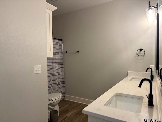 bathroom featuring hardwood / wood-style flooring, vanity, curtained shower, and toilet