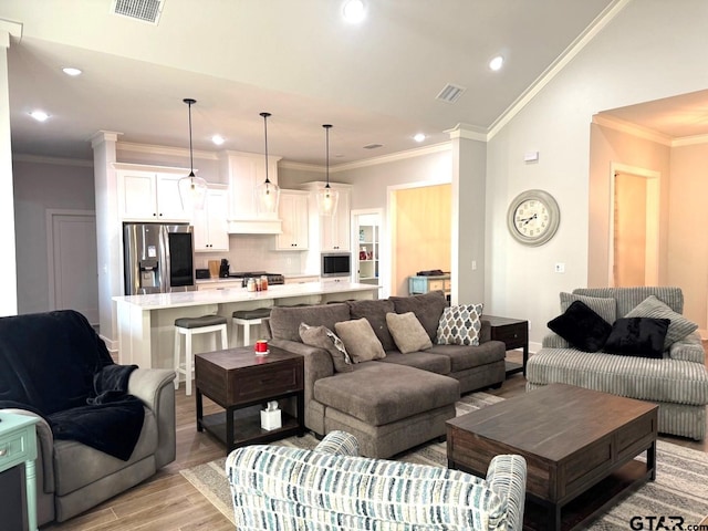 living room featuring ornamental molding and light hardwood / wood-style floors