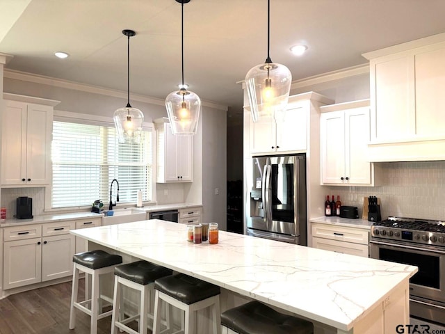 kitchen featuring appliances with stainless steel finishes, a kitchen bar, a kitchen island, and white cabinets