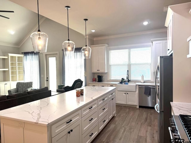 kitchen with a kitchen island, appliances with stainless steel finishes, white cabinetry, sink, and hanging light fixtures