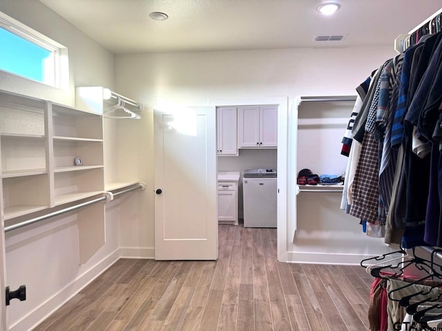 spacious closet with washer / dryer and light wood-type flooring