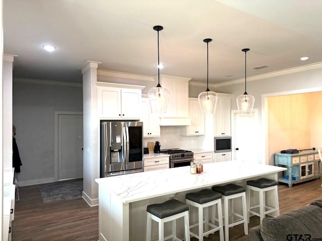 kitchen with appliances with stainless steel finishes, a center island, light stone countertops, and white cabinets