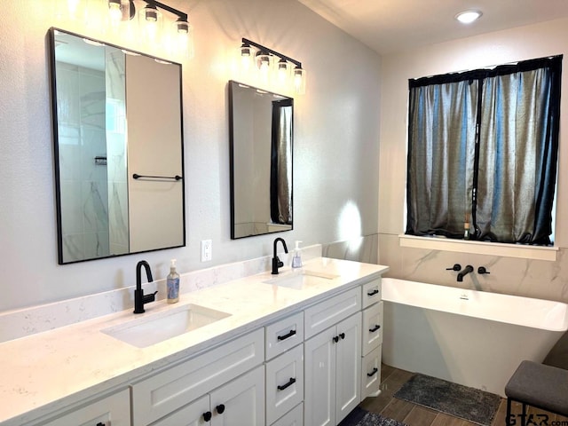 bathroom featuring vanity, a bath, and wood-type flooring