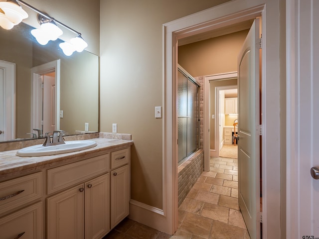 bathroom featuring vanity and combined bath / shower with glass door