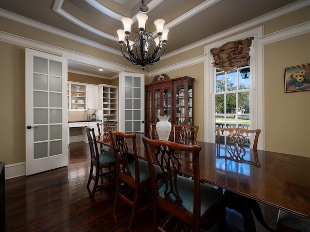 dining space featuring ornamental molding, dark hardwood / wood-style floors, a tray ceiling, a notable chandelier, and french doors