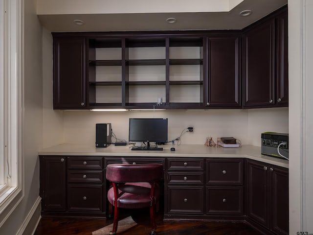 office space with built in desk and dark hardwood / wood-style floors