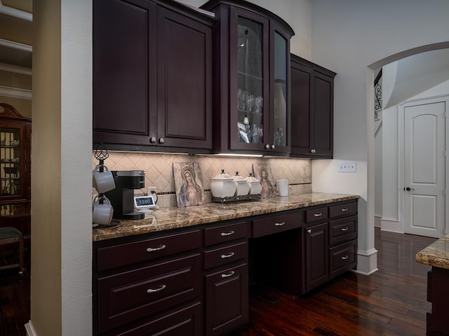 kitchen with dark brown cabinetry, tasteful backsplash, dark hardwood / wood-style floors, and light stone counters