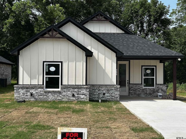 300RODENAVENU 300 Roden Ave, Gladewater, TX 75647 - view of front of house featuring roof with shingles, board and batten siding, a front yard, and central AC unit