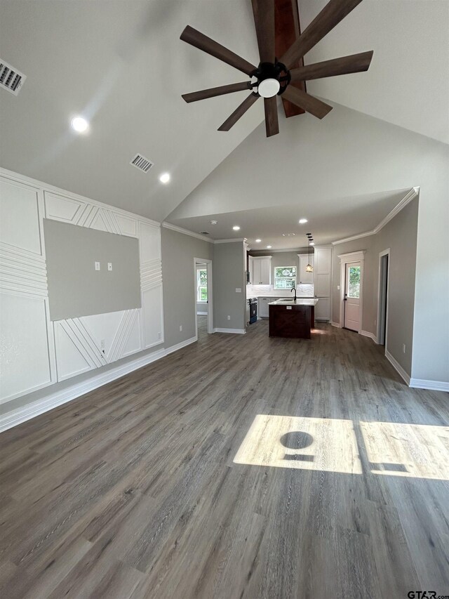 300RODENAVENU 300 Roden Ave, Gladewater, TX 75647 - unfurnished living room with a ceiling fan, baseboards, high vaulted ceiling, wood finished floors, and recessed lighting