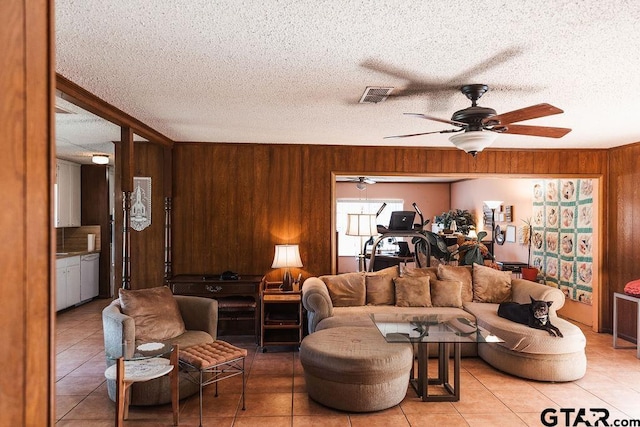8105 Jewell Ln, Tyler, TX 75703 - living room with wood walls, a ceiling fan, visible vents, and light tile patterned floors