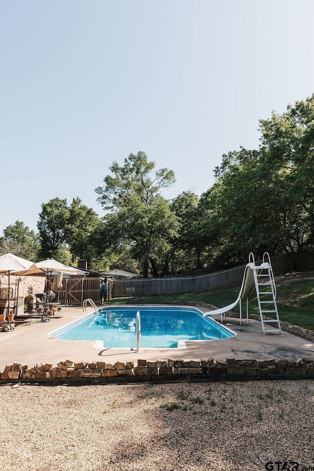 8105 Jewell Ln, Tyler, TX 75703 - view of swimming pool featuring a fenced backyard, a water slide, a fenced in pool, and a patio