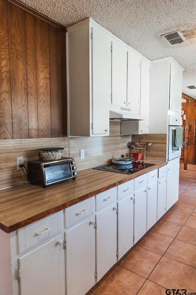8105 Jewell Ln, Tyler, TX 75703 - kitchen with white oven, visible vents, wood counters, and under cabinet range hood
