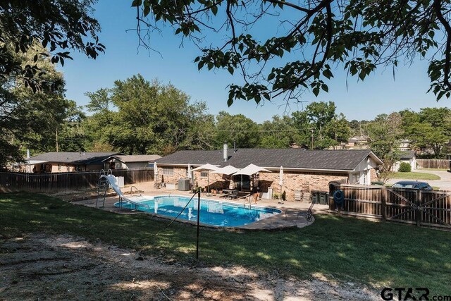 8105 Jewell Ln, Tyler, TX 75703 - view of swimming pool with a patio area, a fenced backyard, a water slide, and a lawn