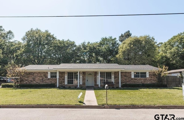 8105 Jewell Ln, Tyler, TX 75703 - ranch-style house featuring a front yard, fence, and brick siding
