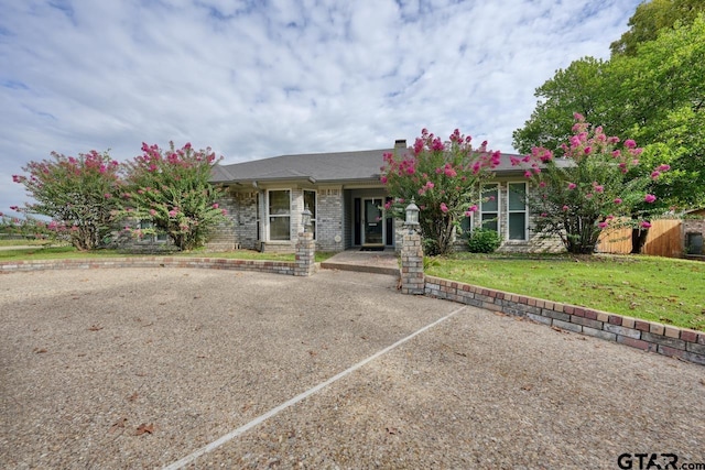 single story home featuring brick siding and a front yard