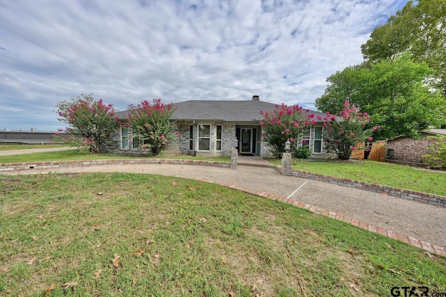 ranch-style house featuring a front lawn and brick siding