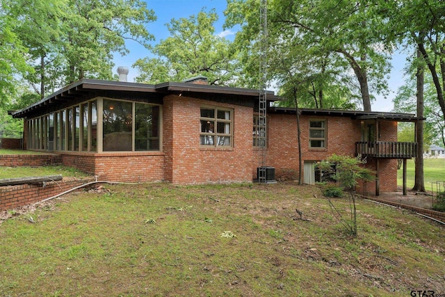 view of home's exterior featuring brick siding, a yard, and central AC unit