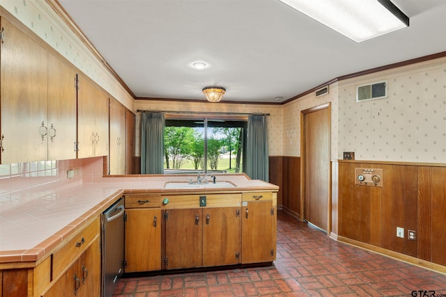 kitchen featuring a sink, tile countertops, a wainscoted wall, ornamental molding, and visible vents