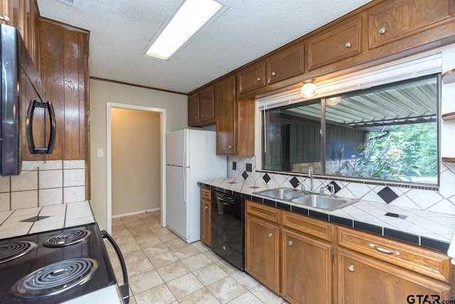 kitchen with tile countertops, a textured ceiling, a sink, decorative backsplash, and black appliances