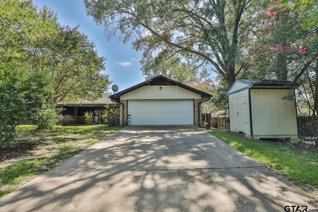 view of front of property featuring an outbuilding, brick siding, an attached garage, a shed, and driveway