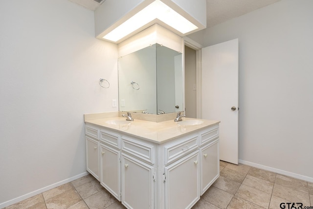 full bathroom featuring double vanity, tile patterned floors, a sink, and baseboards