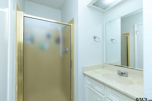 full bath with a textured ceiling, a stall shower, and vanity