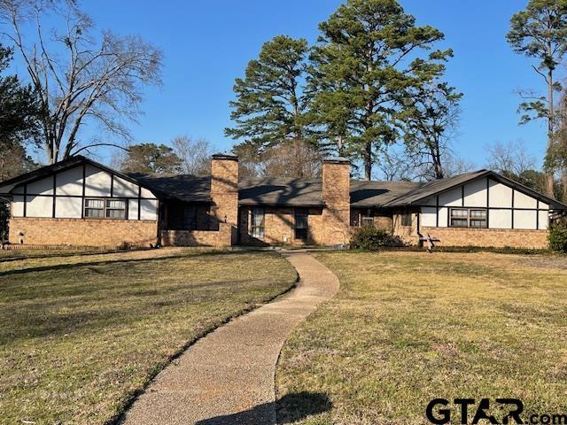 view of front of home featuring a chimney and a front yard