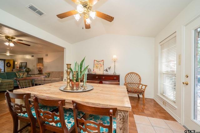 dining room with ceiling fan, light parquet flooring, and lofted ceiling