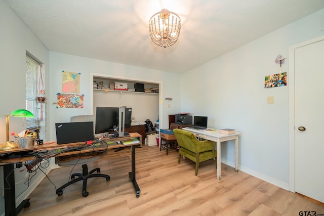 office space with an inviting chandelier and light wood-type flooring