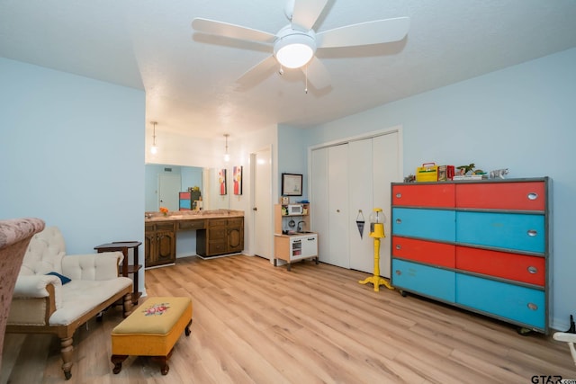 sitting room with light hardwood / wood-style floors and ceiling fan