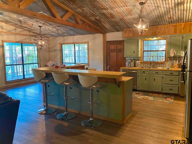 kitchen with hanging light fixtures, vaulted ceiling with beams, and a breakfast bar